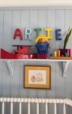 there is a shelf with some toys on it and letters above the shelves that spell out art