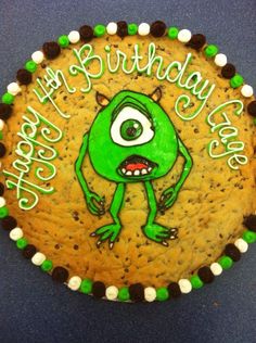 a cookie decorated with green and white icing that says happy birthday to the monster