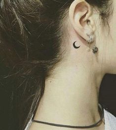 a woman's ear is shown with a small crescent tattoo on her left side