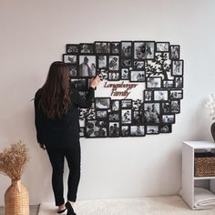 a woman standing in front of a wall with pictures on it and writing happy family