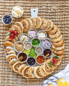 an assortment of finger foods arranged in a circle on top of a woven place mat