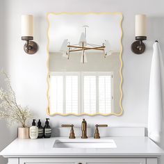 a bathroom with a sink, mirror and two lights on the wall next to it