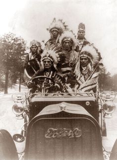 an old photo of native americans riding in the back of a car