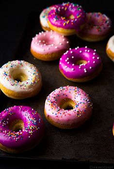 there are many donuts with pink frosting and sprinkles on them