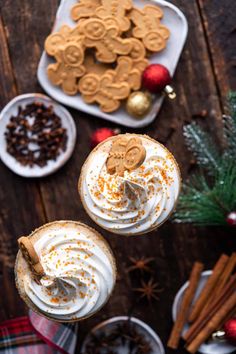 two glasses filled with hot chocolate and topped with marshmallows, pretzels and gingerbread cookies