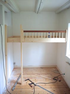 an unfinished room with wood flooring and a ladder on the wall next to it