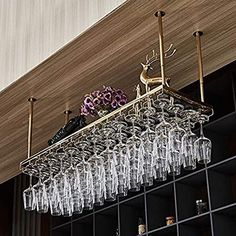 a rack with wine glasses hanging from it's sides on a shelf in a room