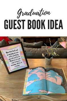 an open book sitting on top of a wooden table next to a vase with flowers