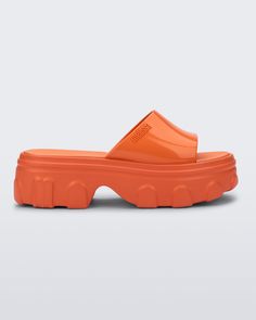 Side view of a orange Ella Slide platform Trendy Jelly Sandals With Rubber Sole For Summer, Trendy Summer Jelly Sandals With Rubber Sole, Bold Platform Sandals For Spring, Bold Spring Platform Sandals, Modern Platform Jelly Sandals In Synthetic Material, Modern Platform Jelly Sandals In Synthetic, Modern Platform Jelly Sandals, Modern Synthetic Platform Jelly Sandals, Summer Clogs With Translucent Outsole