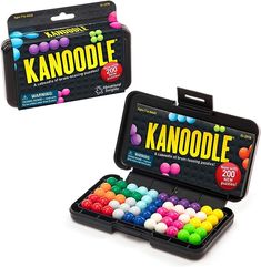 two black boxes filled with assorted colored candies on top of a white surface