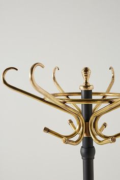 an umbrella stand with gold colored metal decorations on it's top and black base