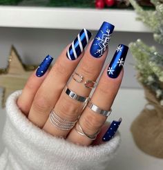 This bold, royal blue manicure stands out with its vibrant color and intricate winter details. One nail features a snowflake pattern, while another is decorated with candy cane-inspired stripes. The deep blue base and white accents create a frosty yet modern design, perfect for ringing in the holiday season with style. Xmas Nail Designs, New Years Nail Designs, December Nails, Cute Christmas Nails, Christmas Nail Art Designs, Blue Nail Designs, Blue Nail