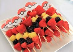 fruit kabobs are arranged on a plate with toothpicks in the shape of pokemon pikachu