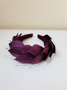 FABRIC This Women's fascinator headband is carefully hand made. The headband has been crafted from the core with padding for comfort and covered in pure silk. The feathers have been trimmed and fixed within the headband. The head crown is light, soft and super comfortable and boasts a quality finish. FIT  A flexible base band to fit all head sizes.  PACKAGING Each headband is wrapped in pretty acid free tissue paper, sealed with an Evierosemade brand sticker and shipped in an eco-friendly cardboard gift box to protect while in transit. If you are purchasing as a gift, please select "This order is a gift" (the item price will not be included in the gift box). If you would also like to add a personalised message to the recipient, please enter your message in the box marked "Add a Note to evi Purple Headpieces With Matching Headband For Party, Purple Headband Fascinator For Royal Ascot, Elegant Purple Headband For Evening, Formal Feathered Headband, Formal Purple Headband Headpiece, Elegant Feather Trim Headband Fascinator, Purple Evening Fascinator With Curved Brim, Adjustable Purple Headband For Evening, Purple Feather Wedding Fascinator