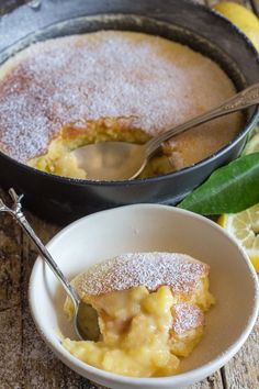 a bowl filled with pudding next to a pan full of lemons and powdered sugar