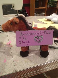 a stuffed horse holding a sign that says home coming 2 - drew