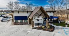 a building with blue awnings and white siding on the side of it in a parking lot