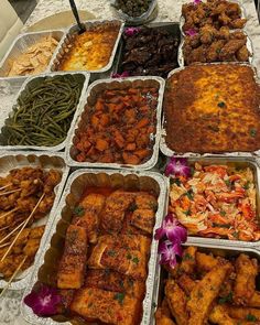 many trays of food are arranged on a table