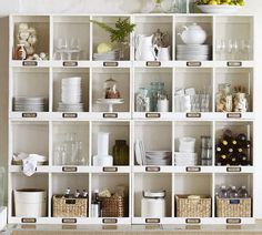 a white shelf filled with lots of dishes and cups