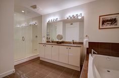 a bathroom with a large tub, sink and shower in it's own area