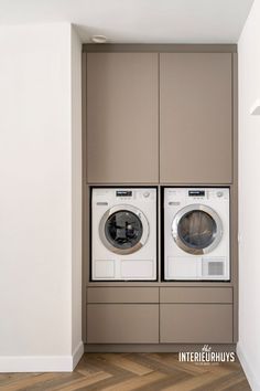 a washer and dryer in a room with wood flooring on the side