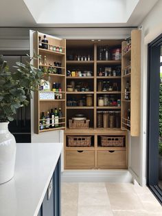 an organized pantry with wooden shelves and drawers