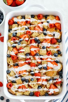 a casserole dish filled with berries, blueberries and strawberries on top