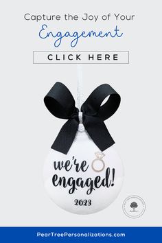 a white ornament with a black ribbon and the words capture the joy of your engagement