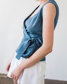 "Fitted, aesthetic, and very elegant sleeveless linen wrap top made from Lithuanian washed linen fabric. Comes with a belt to tie on the side for an effortless but well put together look. FABRIC: 100% Washed Lithuanian Linen COLOR: Please choose the desired color from the side menu. STYLE: Fitted linen sleeveless wrap top with a belt tied on the side. SIZE CHART: 2 US/ 6 AU/ 34 EU: Bust 31.5\" (80 cm) , Waist 23\" (59 cm), Hips 35\" (88 cm) 4 US/ 8 AU/ 36 EU: Bust 33\" (84 cm) , Waist 25\" (63,5 Blue Linen V-neck Blouse, Cotton Wrap Top For Summer, Chic Cotton Wrap Top For Summer, Summer Cotton V-neck Wrap Top, Casual Cotton Wrap Top, Summer Wrap Cotton Tops, Fitted Sleeveless Wrap Top Casual, Sleeveless Blue Linen Top, Casual Linen Wrap Top