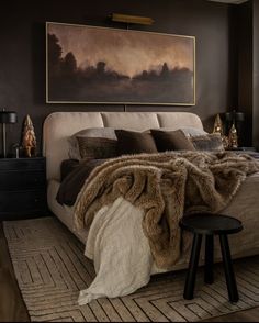 a bedroom with a large painting above the bed