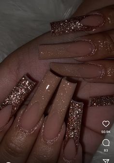 someone is holding their nails with gold glitter on the tip and one nail has been done