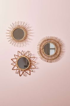 three mirrors on a pink wall with gold accents