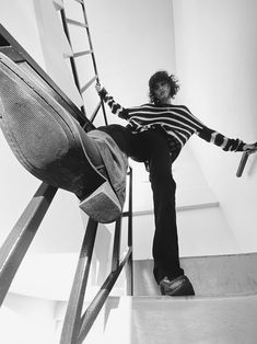 a man sitting on top of a chair next to a ladder