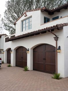 a car parked in front of a house with two garage doors on the side of it