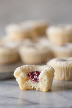 a muffin that has been cut in half and is sitting on a table with other muffins behind it