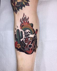 a person with a tattoo on their leg that has a guitar and skull in it