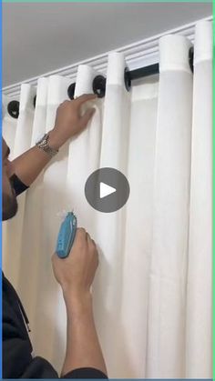 a man is using a window sealer to clean the curtains