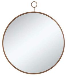 a round mirror hanging on the wall with a metal ring around it's edge