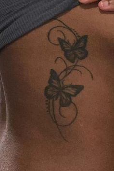 a woman's stomach with a butterfly tattoo on it