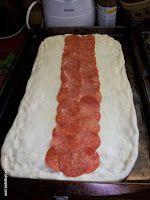 a hot dog bun is being prepared on a baking sheet for the oven to bake