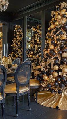 a christmas tree is decorated with gold and black ornaments in an elegant dining room setting