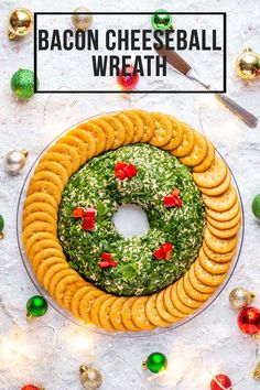 a cheeseball wreath on a platter with crackers and christmas ornaments around it