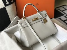 Description HRMS Kelly 28 Retourne Togo White Bag For Women, Handbags, Shoulder Bags 11in/28cm Rep 1:1 Size: 28 x 22 x 10 cm / 11 x 8.5 x 4.5 inches (Length x Height x Width) Hermès bags are considered the ultimate luxury item worldwide. Each piece is handcrafted with waitlists that can exceed a year or more. The streamlined and demure Kelly style is always in high demand, it is particularly lovely in this vibrant version with gold hardware. Epsom is textured with a wonderful grainy appearance. High-end Tan Satchel Bag, High-end Tan Everyday Bag, High-end Handheld Office Bag, High-end Tan Bags For Office, High-end Tan Office Bags, Tan Shoulder Bag For Office, Classic Tan Bags With Dust Bag, Classic Tan Bags With Dust Bag Included, Tan Handheld Bag With Detachable Handle