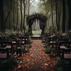 an outdoor ceremony set up in the woods with candles and flowers on each aisle, surrounded by trees