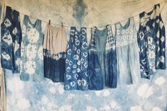 clothes hanging on a line in front of a tie - dyed wall with blue and white colors