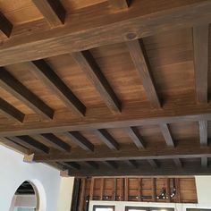 an unfinished wooden ceiling in a kitchen with white walls and wood beams on the ceiling