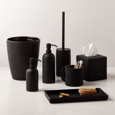 black bathroom accessories including soap dispenser and brush