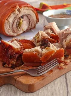 a wooden cutting board topped with meat and sauce