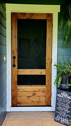 a front door with a sign and potted plants