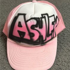 Ashley Airbrushed Name Sun Cap Trucker Hat Adjustable Strapback Pink Pink Flat Bill Hat With Letter Print, Trendy White Streetwear Hat, Trendy White Hats For Streetwear, Trendy White Hat For Streetwear, White Hats For Spring Streetwear, White Trucker Hat With Letter Print, White Trucker Hat With Letter Print And Flat Brim, Hip Hop Pink Snapback Hat, Pink Hip Hop Snapback Hat